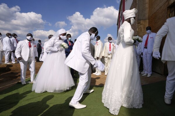 Couples dance as they enter the church building during mass Easter weddings for 3,000 people, some polygamous, at the International Pentecost Holiness Church, in Heidelberg, east of Johannesburg, South Africa, Sunday, April 20, 2025. (AP Photo/Themba Hadebe)